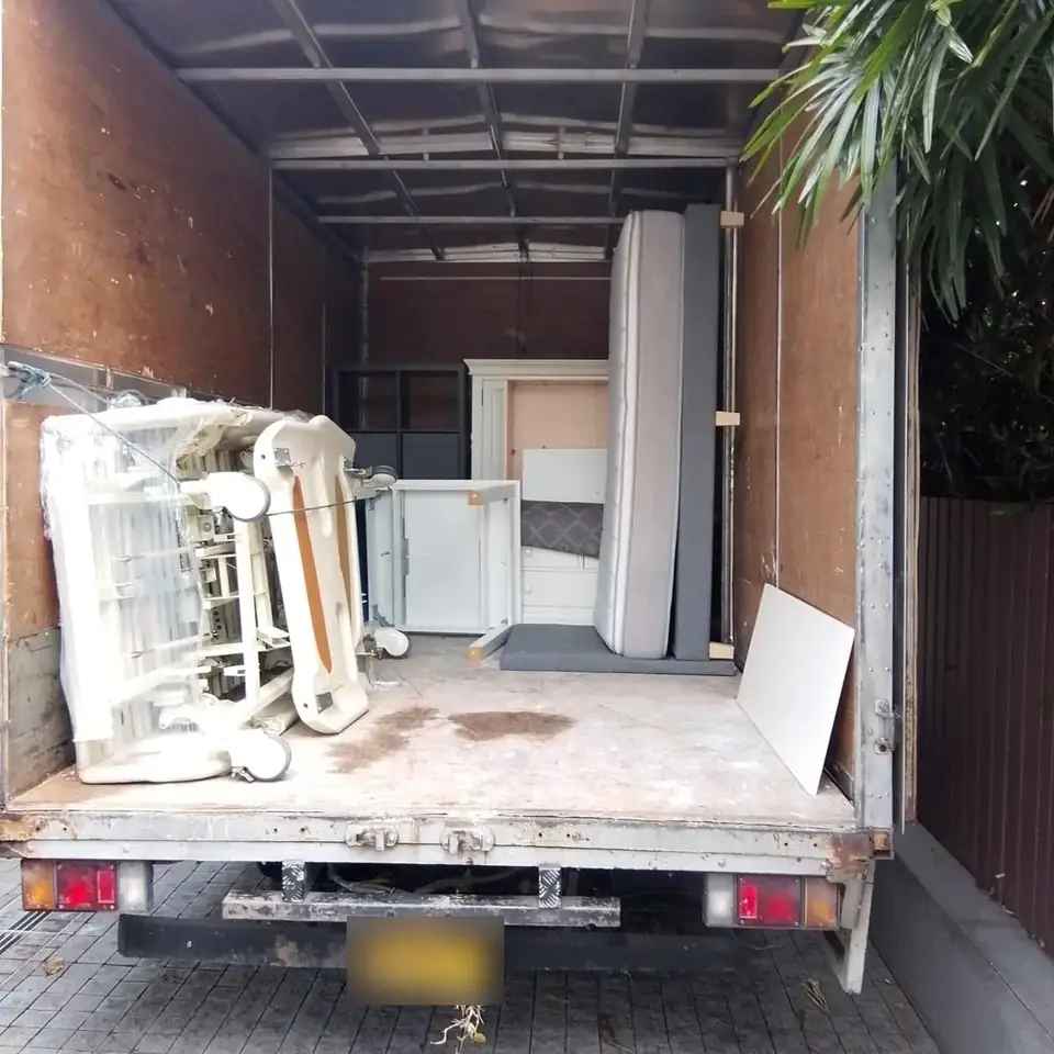 Bulky household furniture and mattress loaded in a disposal truck